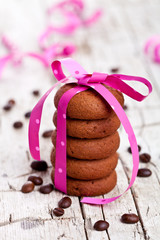 stack of chocolate cookies tied with pink ribbon and coffee bean