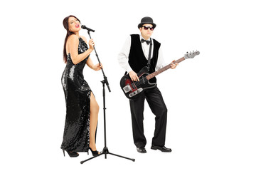 Man playing a bass guitar and woman singing