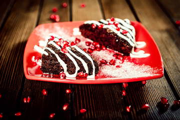 Christmas chocolate cake dessert with pomegranate on wooden tabl