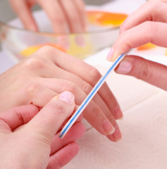 Obraz na płótnie Canvas Beautician with file filing nails female client. Beauty salon.