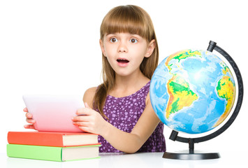 Young girl is using tablet while studying