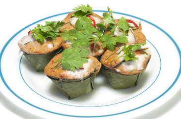 Streamed curry fish in banana leaf cup isolated.