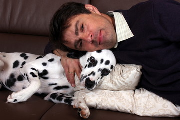 Herrchen und Dalmatiner kuscheln auf Sofa