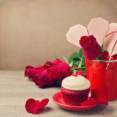 Valentine's day cupcake and roses on wooden table
