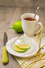 Lemon and cup of tea on wooden table