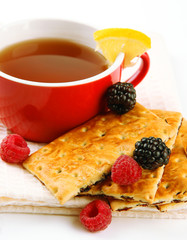 Cup of tea with cookies and berries isolated on white