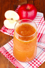 Glass of fresh apple juice on wooden table