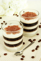 Tasty jelly coffee with milk on table on light background