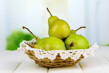 Pears in  wicker basket, on light background