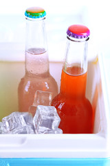 Drinks in glass bottles in mini fridge close up
