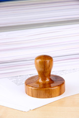 Wooden stamp and papers on table
