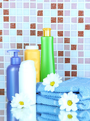 Obraz na płótnie Canvas Cosmetics and bath accessories on mosaic tiles background