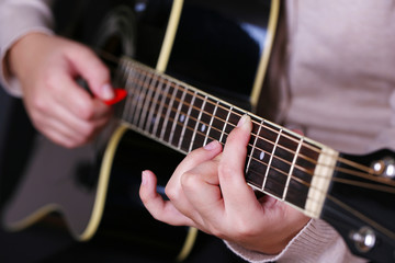 Obraz na płótnie Canvas Gitara akustyczna w rękach kobiet, zbliżenie