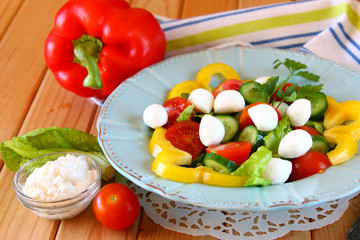 salad with mozzarella and fresh vegetables on wooden table