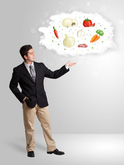 Fototapeta premium Handsome man presenting a cloud of healthy nutritional vegetable