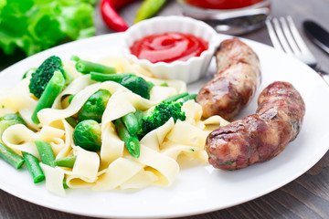 Fettuccine with vegetables and fried sausages