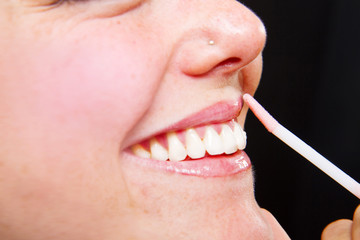 Obraz premium Make-up artist applying lipstick with a brush