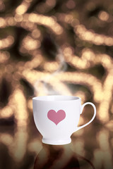 coffee cup against bokeh background with hearts