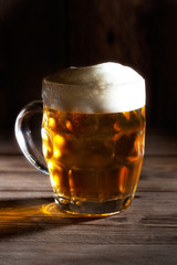Mug of beer on wooden background