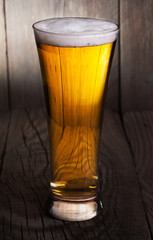 Mug of beer on wooden background