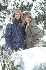 Happy couple embracing in winter forest