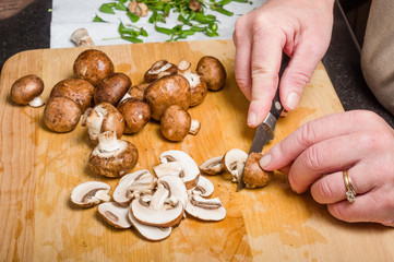 Cook slicing mushrooms in kitchen