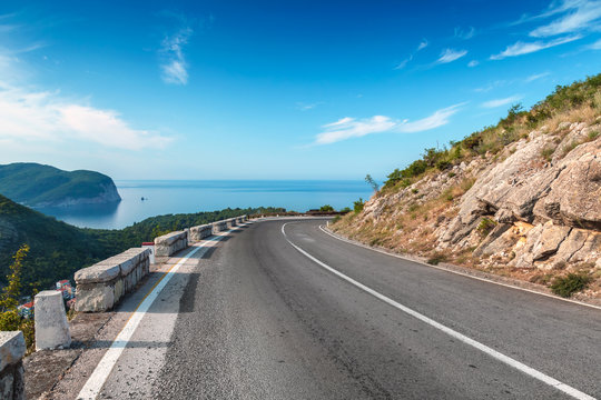 Turning mountain highway with blue sky and sea on a background