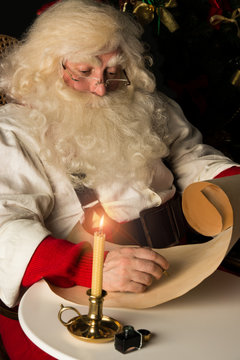 Santa Claus sitting at home and writing a letter