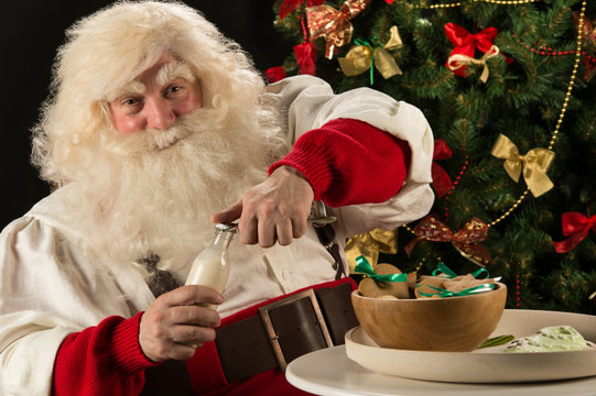 Santa Claus eating cookies with milk