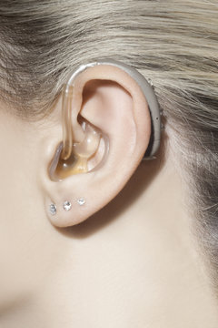 Beautiful woman ear with hearing aid
