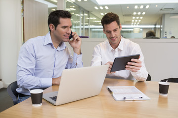 Fototapeta na wymiar Two casual businessmen working together in modern office