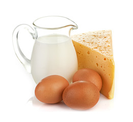 Big piece of cheese, glass jug with milk