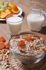 Oat flakes with dried fruit and milk and fresh fruit.  vertical