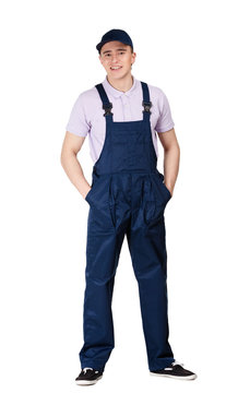 Workman in blue overalls and peaked cap, isolated on white