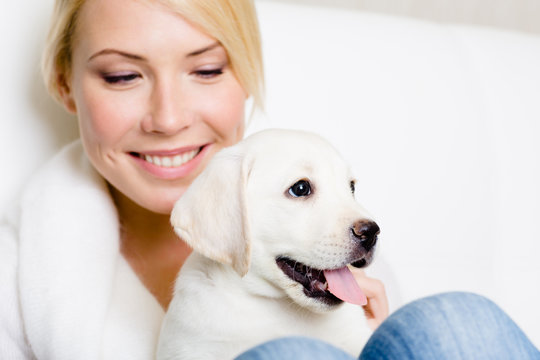 Close up of woman in white sweater with labrador puppy 