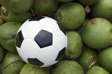 Soccer Ball Football Resting with Fresh Green Coconuts
