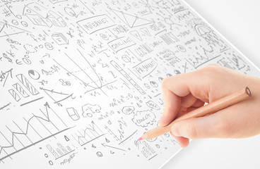 Human hand sketching ideas on a white paper