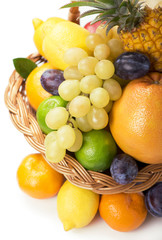 Naklejka na ściany i meble Fresh fruit in a wicker basket on the white
