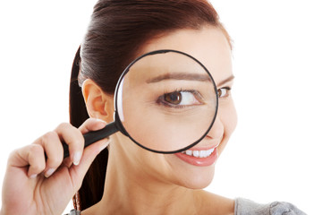 Young beautiful woman with magnifying glass.