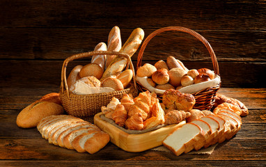 Obrazy na Plexi  Różnorodność chleba w wiklinowym koszu na stare drewniane tła.