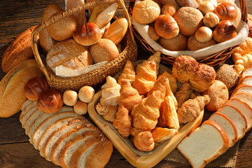 Verscheidenheid van brood in rieten mand op oude houten achtergrond.
