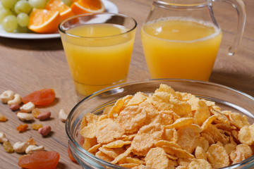 Cornflakes with fruits, nuts and orange juice. close-up