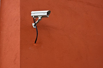CCTV security camera and red wall.