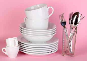 Clean white dishes on pink background