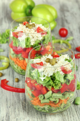 Tasty salad with fresh vegetables on wooden table