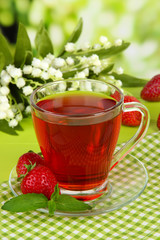 Delicious strawberry tea on table on bright background