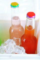 Drinks in glass bottles in mini fridge close up