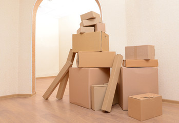 Fototapeta premium Empty room with stack of cartons: moving house concept