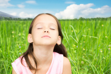 Cute little girl resting in high grass