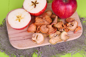 Dried apples, on cutting board,  on color wooden background